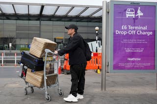 A traveller arrives with his lugage at Terminal 4 as Britain's Heathrow Airport has closed for the full day Friday after an electrical substation fire knocked out its power